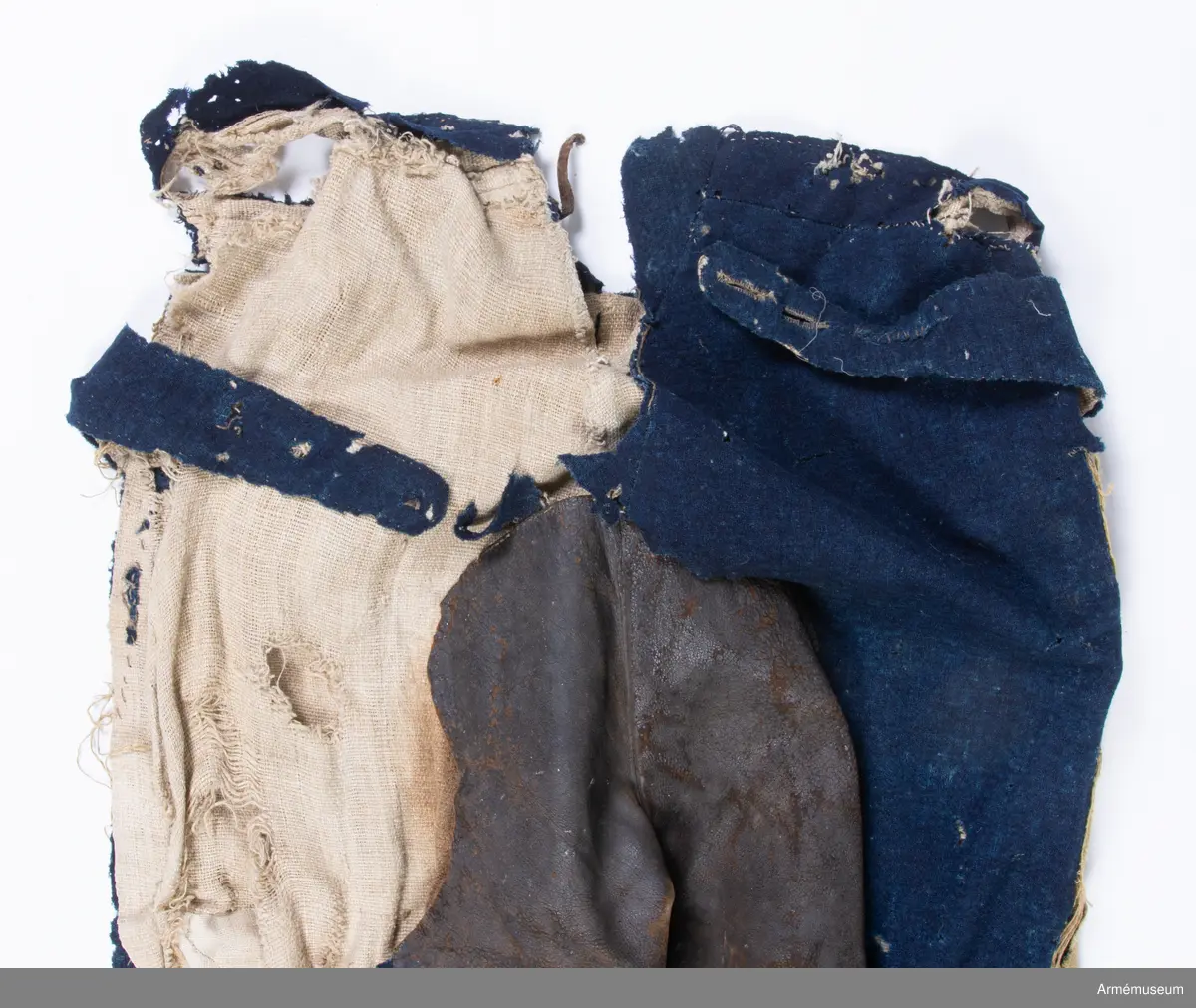 Blå ridbyxor med gula revärer och skinnskodda ben och byxbak.

Byxorna är sydda av ett ganska tunt blått kommisskläde, och är helfodrade med oblekt linne- eller hampalärft.
Modellen är konstruerad med två fram- och två bakstycken, och har hel lucka fram som har knäppts mot en gördel eller linning. Luckan har 5 knapphål fram, varav tre har knäppts mot gördeln. I luckans sidor upptill sitter två spänntampar för knäppning bak i ryggslutet. I sömmen bak sitter en infälld kil för reglering av midjevidden, samt en hank av läder för upphängning.
I sidan har byxorna revärar av 4 cm breda gula redgarnsband.
Byxbenen är skodda med brunt skinn i en höjd av ca 36 cm nertill. Kanten är formad i två bågar fram och en spets bak. Skinnskoningen fortsätter på baksidan upp på insidan av låren och i byxbaken.
Byxorna är mycket trasiga och malätna, och både yttertyg och foder har lagats ett flertal gånger under deras användningstid.
Samtliga knappar saknas förutom i höger byxben längst ner där det sitter rester av enkla skinnknappar i varje sida.

Märkt på insidan "LS No 2".