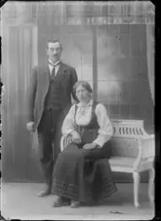 Studioportrett av kvinne og mann oppstilt i fotostudio.