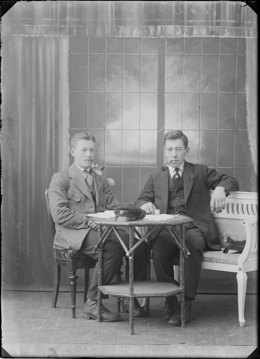 Portrettfoto. To menn oppstilt i fotostudio.