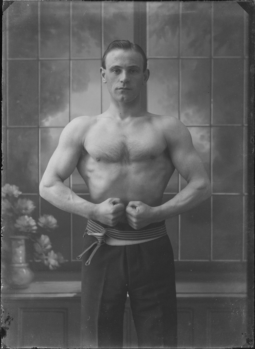 Portrettfotografi. Mann oppstilt i fotostudio i bar overkropp.
