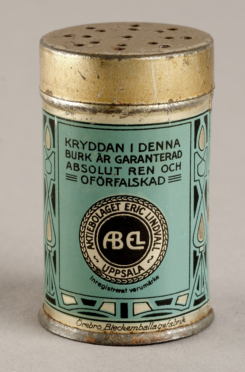 Plåtburk. Blå, svart och silvrig. TEXT: Aktiebolaget Eric Lindvall Uppsala. Kryddan i denna burk är gatanteratd absolut ren och oförfalskad.