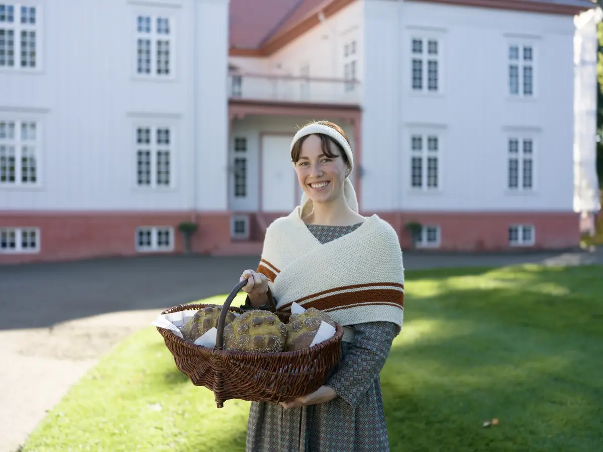 Jente med brødkurv foran Eidsvollsbygningen