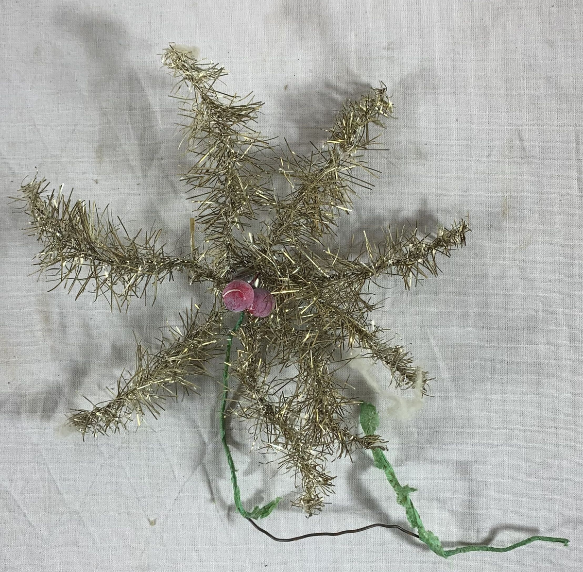Fem julepyntede stjerner, sannsynligvis beregnet for plassering på toppen av et juletre. Hver stjerne er formet av metalltråd innpakket i sølvfarget glitterdekor, med noen som har små røde kuler som ekstra pynt. Glitteret gir en strålende og festlig effekt, selv om noen av stjernene har tegn til slitasje med deler av glitteret som er borte, og stjerneformene er noe deformert. 

