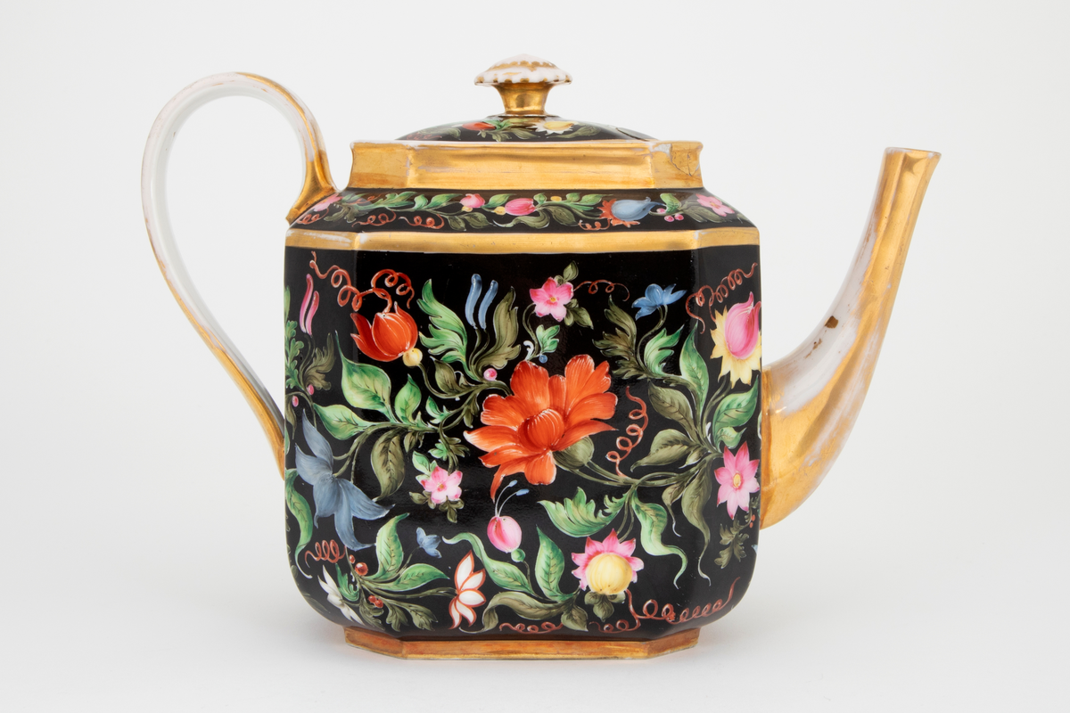 Kaffekanne i glasert porselen med polykrom blomsterdekor på svart bunn og forgylte kanter, tut, lokknapp og hank. Kannen har firkantet form med avfasede hjørner.
