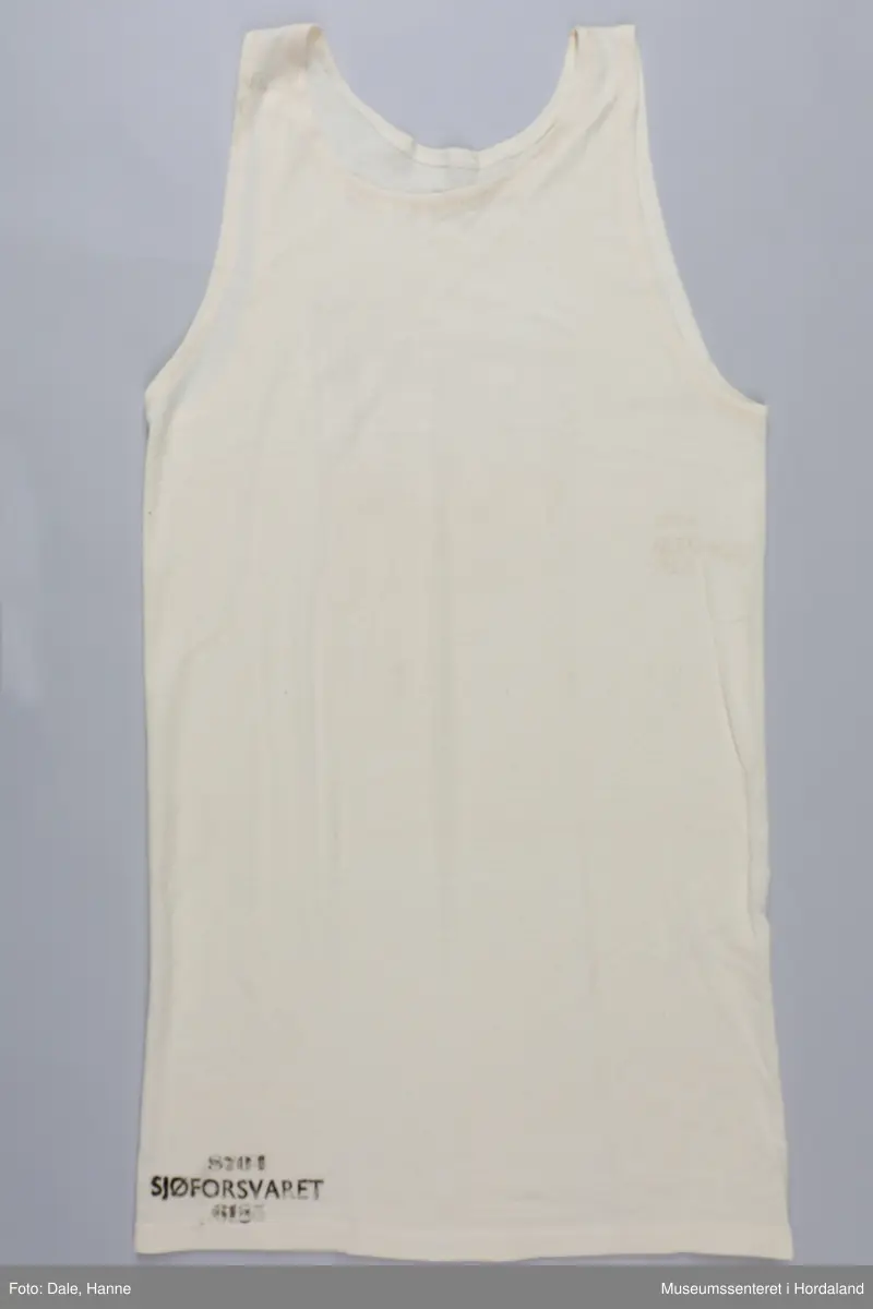 Trøye uten erm, "singlet", undertøy til menn. Industristrikk produsert for Sjøforsvaret: trøya er merka "8704 Sjøforsvaret 6185".