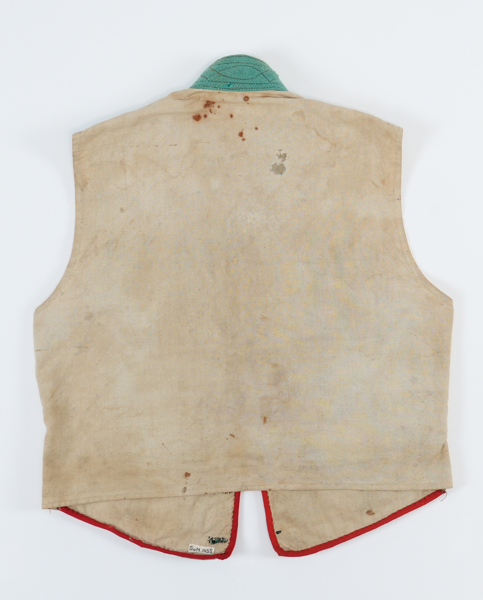 Vest med høg dobbellagd krage, med brune stikningar. Ein liten rund opning mellom kragen og kneppinga. Enkel knapperad, 7 "matrosknappar", det nederste knappet er litt anneledes fra de andre. Avrunda i framkant. Stikklomme med stolpeklaff på kvar side. Framstykka er fora, same stoffet er brukt som bakstykke. Opning og lommekaffar kanta med raude mohairband.