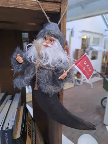 Julepynt: En gråkledd julenisse med et god jul- flagg. 