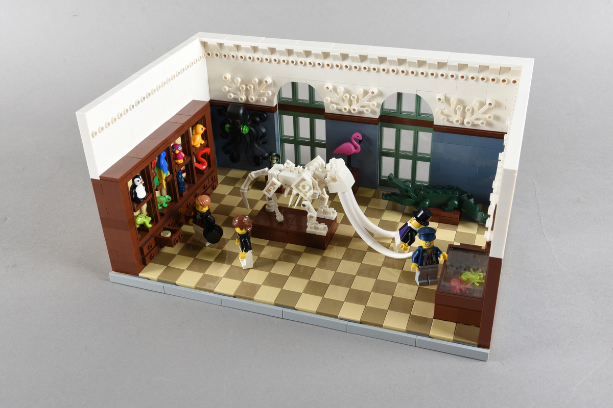 Tablået er bygget av Lego i diverse farger. Scene med fire mennesker i et naturaliekabinett. Dresden, 1. september 1823. Det kongelige naturaliekabinettet.