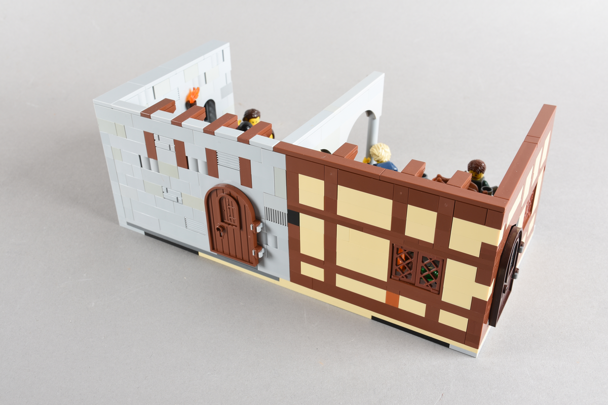 Tablået er bygget av Lego i diverse farger, satt sammen til å forestille to forskjellige scener på et vertshus i Paris, ca. 1265.