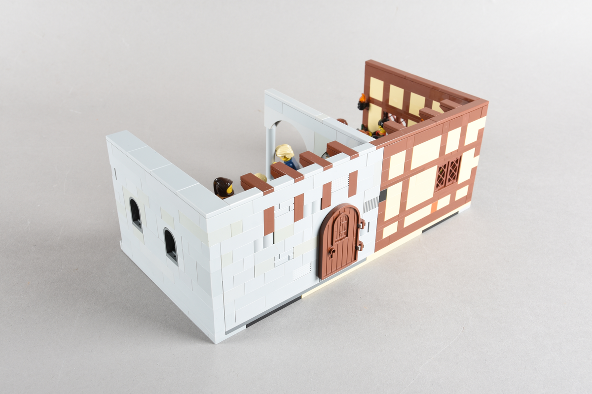 Tablået er bygget av Lego i diverse farger, satt sammen til å forestille to forskjellige scener på et vertshus i Paris, ca. 1265.