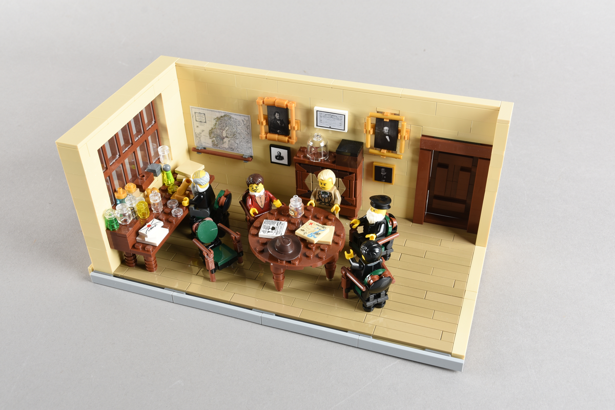 Tablået er bygget av Lego i diverse farger. Scene med fem mennesker i en skildring av det vitenskapelige miljøet ved Bergens Museum. Bergen 1886, Direksjonsværelset, Bergens Museum.