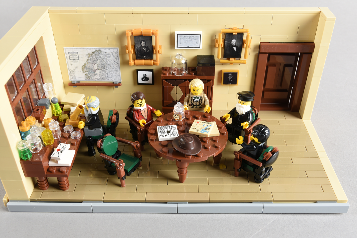 Tablået er bygget av Lego i diverse farger. Scene med fem mennesker i en skildring av det vitenskapelige miljøet ved Bergens Museum. Bergen 1886, Direksjonsværelset, Bergens Museum.