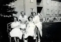 Fyra kvinnliga sjukvårdsbiträden sitter/står i en fint tillv