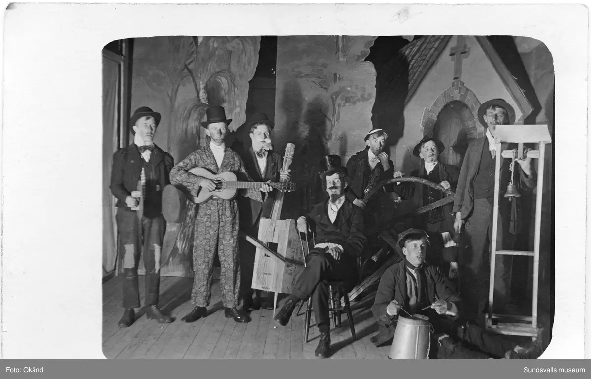 Två vykort från samma tillfälle med en teatergrupp. På första bilden en scen med rekvisita och musikinstrument, på andra bilden hela ensemblen. Ur en samling som tillhört Olivia Larsson, Svartvik.