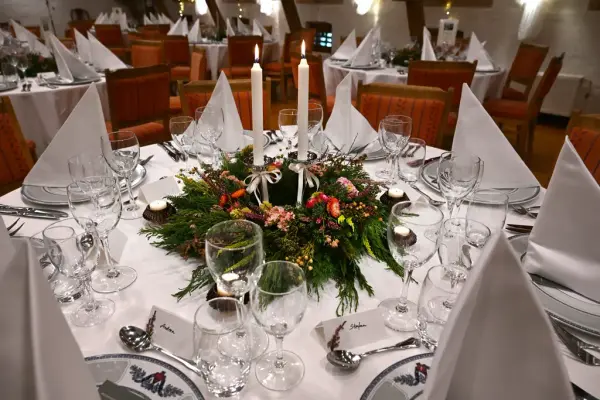 Bord dekket til selskap med julekrans og levende lys. 