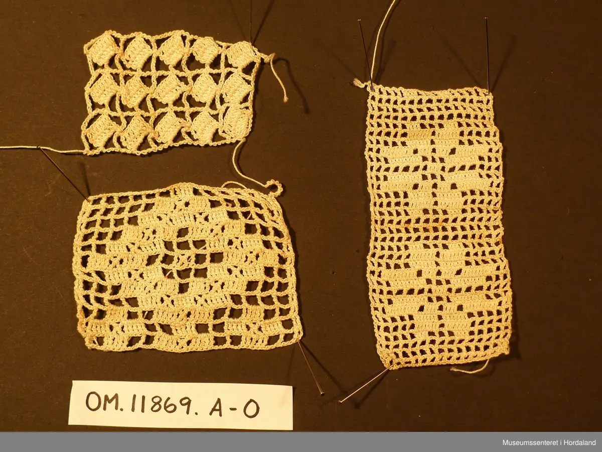 Kvadratisk, hekla stykke som truleg er tenkt samansett til eit større arbeid. Heklearbeidet er gjort i fint, kvitt bomulsgarn som er gulna av elde.
