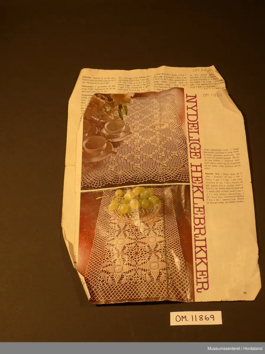 Kvadratisk, hekla stykke som truleg er tenkt samansett til eit større arbeid. Heklearbeidet er gjort i fint, kvitt bomulsgarn som er gulna av elde.
