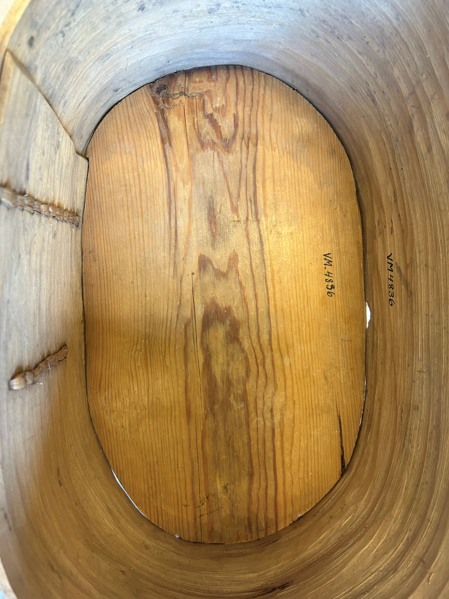 Oval bottenyta, ristad dekor med svart ifärgning. Lös botten.