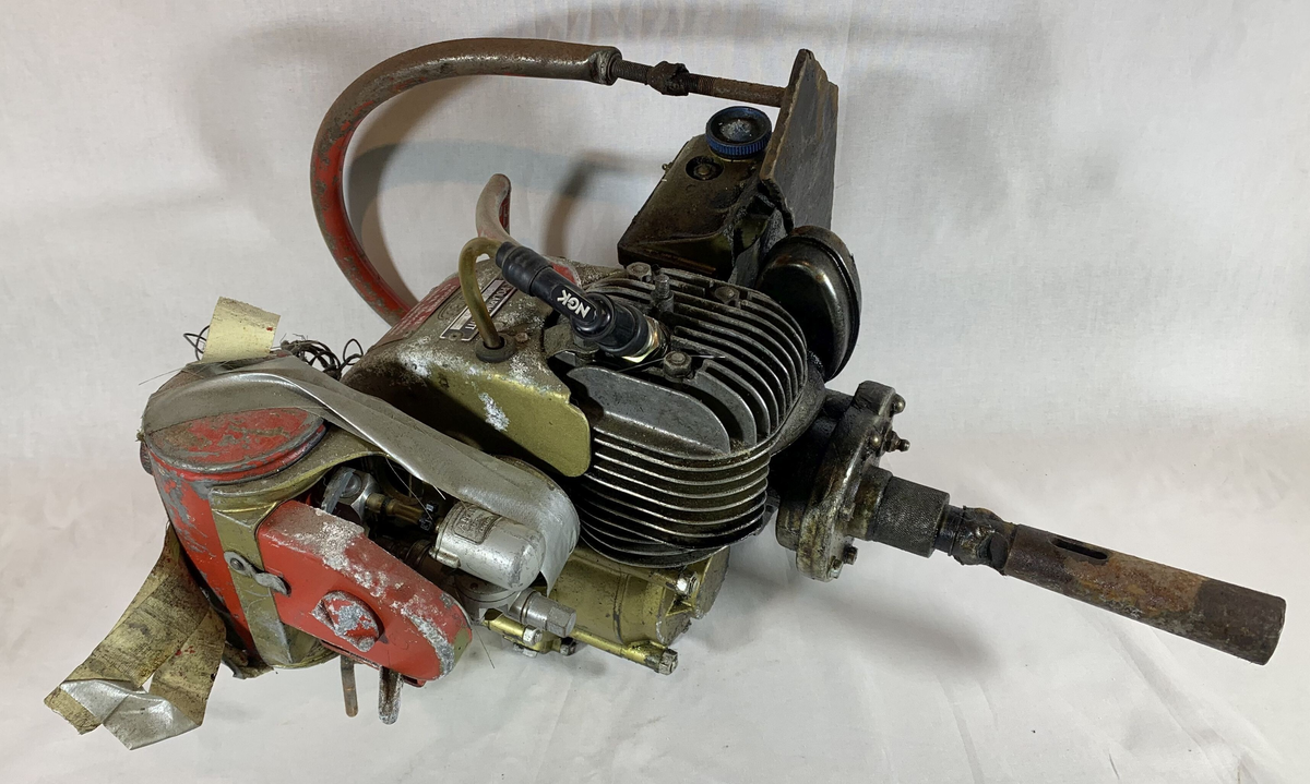 Denne gjenstanden består av en Jobu Junior Super motorsagmotor uten kjede og sverd til saga som indikerer at den ble brukt som en påhengsmotor eller motor til boring eller lignende. Denne motoren har vært brukt av Norsk Polarinstitutt i Ny-Ålesund på Svalbard. En tydelig advarselsplakett på motoren sier at "Motoren må gå på tomgang når sagkjeden kobles inn." Den er utstyrt med en forgasser fra AMAL Birmingham England. Gjenstanden er nummerert med serienummeret A58470 og patentnummer 31808 fra Jobu, Oslo, Norway.