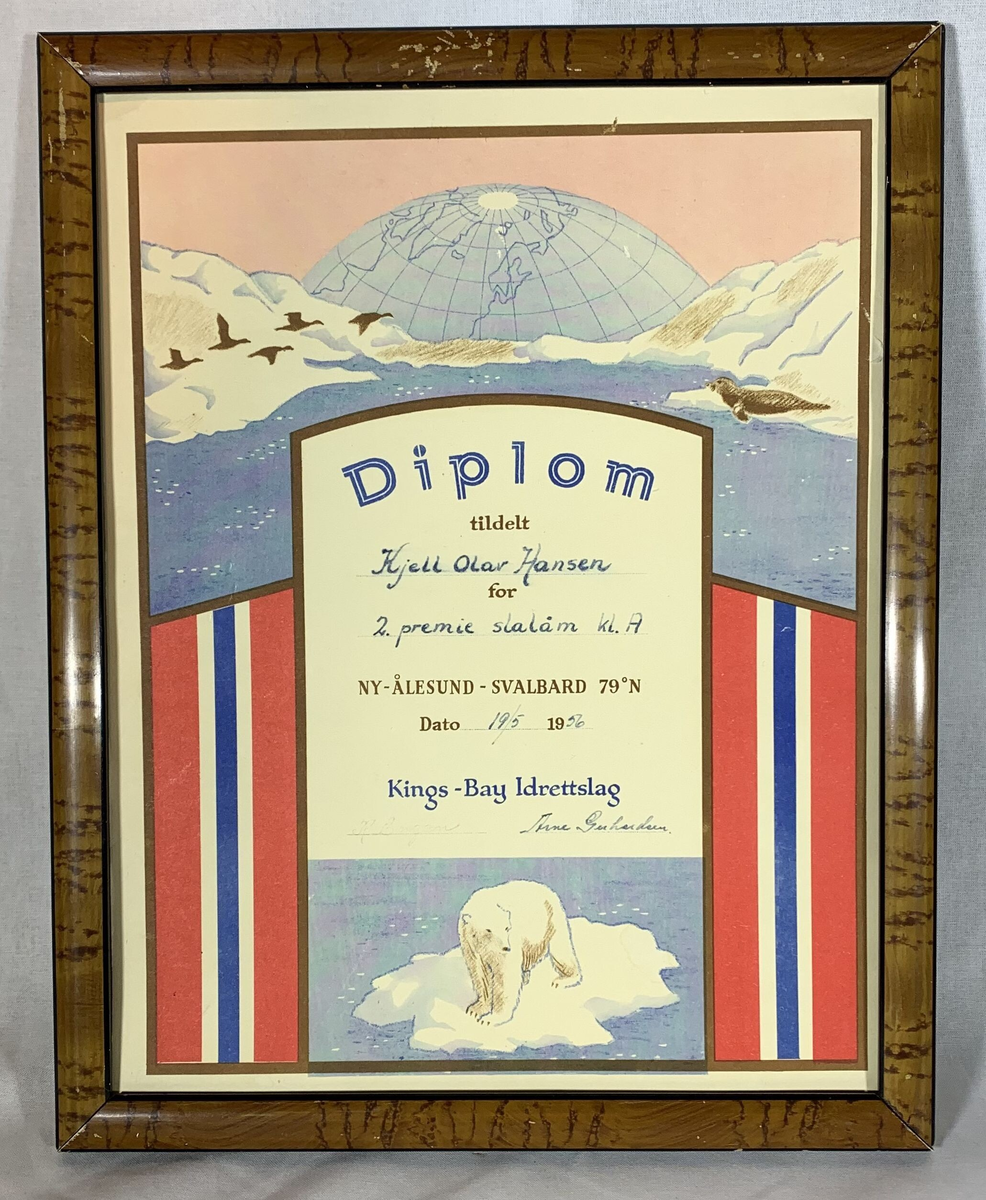 Et innrammet diplom fra Kings Bay Idrettslag, tildelt Kjell Olav Hansen for 2. premie i slalåm klasse A. Diplomet er datert 19. mai 1976 og ble utstedt i Ny-Ålesund, Svalbard. Det grafiske motivet på diplomet inkluderer et isbjørnmotiv nederst og et landskapsbilde av fjorder og fjell i bakgrunnen, med en illustrasjon av en globus som viser Arktis. Rammen er laget av mørkbeiset treverk.