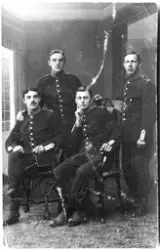 Vykort med ateljéporträtt av fyra unga soldater i uniform fr