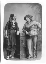 Vykort med ateljéporträtt av två personer klädda i maskerad-