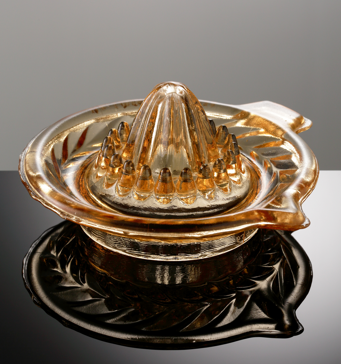 Citronpress.
Tillverkad på Sölvesborgs glasbruk (I=1896-1898, II=1914-1970).
Bladranka i relief på undersidan av brättet. Ojämn kant.
Svagt orangebrunt klarglas.

Inskrivet i huvudkatalogen 1974.