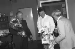 John Berthung overrekkes blomster på 70-årsdagen.