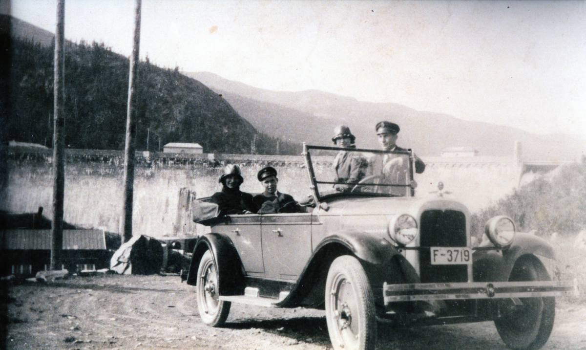 Ved Tunhovddammen. Arne Søndreli er sjåfør og Knut Brøto sit bak sjåføren. Bilen er ein Chevrolet 1927-modell med reg.nr F-3719 som Arne hadde kjøpt ny eller nesten ny.
Damene på biletet skal væra systrene Borghild Lie (i baksetet) og Anne Lie (ved sida av sjåføren).
