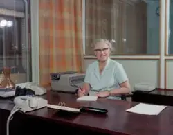 J.L. Nerlien fotofirma, interiør, kontor, kvinne, sittende v