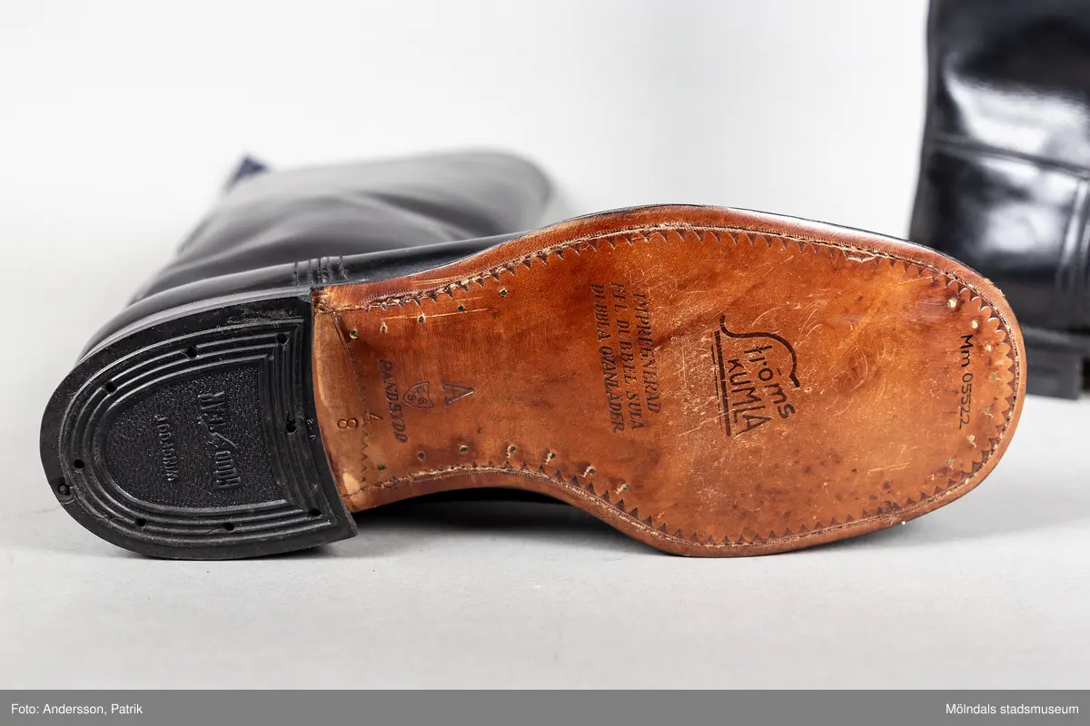 Ett par svarta ridstövlar i läder. Stövlarna är tillverkade på Ströms skofabrik i Kumla på 1950-talet och är mycket välgjorda. Dubbla sulor och handsydd randsula. Stövlarna har en flärp vid skaftets högsta punkt för att underlätta påklädning.  

Stövlarna hör till ridbyxor och härstammar från tidigt 50-tal.
Stövlarna tillhörde en flykting från Estland. Han flydde från Estland år 1944, under andra världskriget och var då 14 år gammal.
Stövlarna var tänkta att användas vid flykt, eftersom den tanken alltid fanns i bakhuvudet. Därför ville man vara väl förberedd med en för flykt passande klädsel. Kläderna kom aldrig till användning för det de var avsedda till.