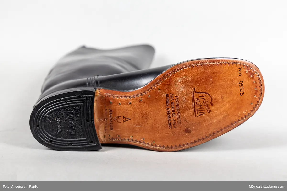 Ett par svarta ridstövlar i läder. Stövlarna är tillverkade på Ströms skofabrik i Kumla på 1950-talet och är mycket välgjorda. Dubbla sulor och handsydd randsula. Stövlarna har en flärp vid skaftets högsta punkt för att underlätta påklädning.  

Stövlarna hör till ridbyxor och härstammar från tidigt 50-tal.
Stövlarna tillhörde en flykting från Estland. Han flydde från Estland år 1944, under andra världskriget och var då 14 år gammal.
Stövlarna var tänkta att användas vid flykt, eftersom den tanken alltid fanns i bakhuvudet. Därför ville man vara väl förberedd med en för flykt passande klädsel.
Kläderna kom aldrig till användning för det de var avsedda till.