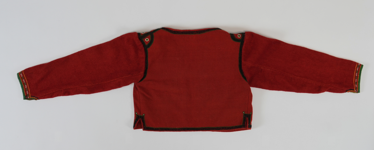 Trøye i tradisjonelt snitt. Open framme, hekta saman nede med krok og malje. Brodert rundt hals, framkant og nedrekant med doble kjedesting og kjedesting. På skuldra halvsirklar og med sirklar av knappholsting. Framme på era grøn kvarde, to rader med kjedesting og ei rad med to grøne og to kvite korssting vekslande.
Erma er gjenbruk frå ei gammal trøye