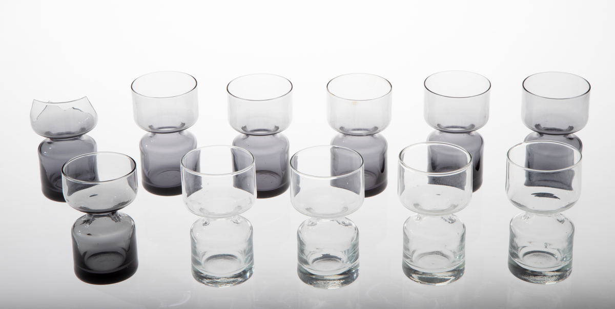 Elleve lysestaker i glass utformet som en sylinder som snevres inn på midten. Den øverste delen er litt videre enn den nederste. 

Fire lysestaker er i klart glass.
Sju lysestaker er i røykfarget, halvgjennomsiktig glass.