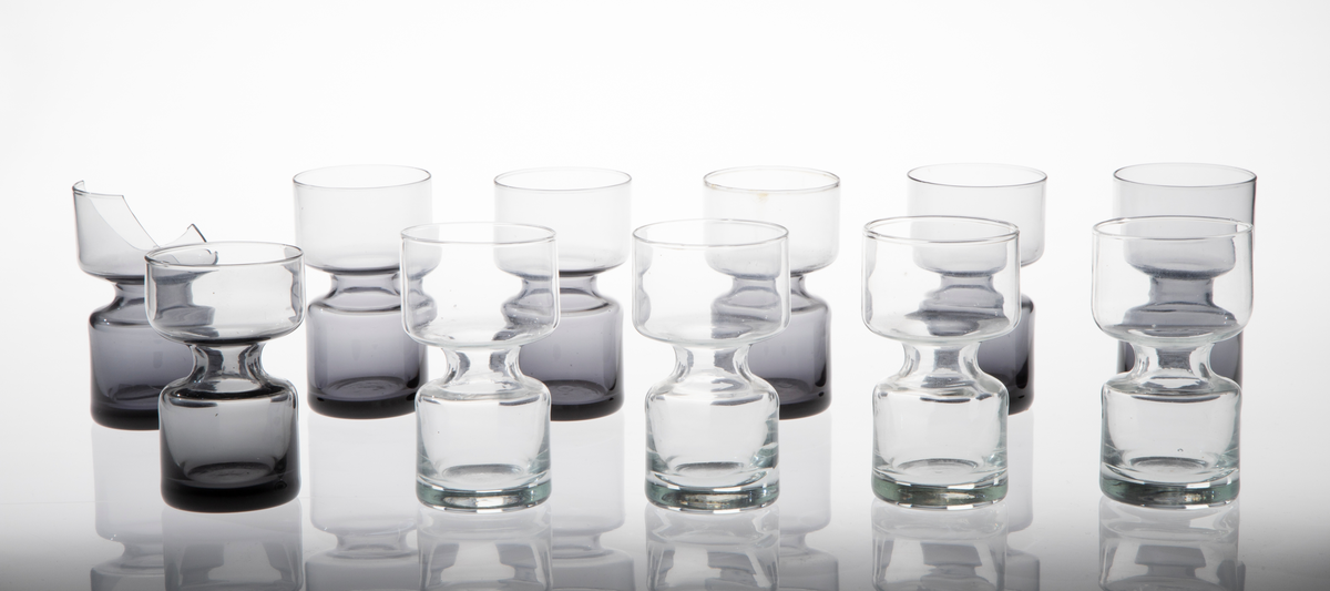 Elleve lysestaker i glass utformet som en sylinder som snevres inn på midten. Den øverste delen er litt videre enn den nederste. 

Fire lysestaker er i klart glass.
Sju lysestaker er i røykfarget, halvgjennomsiktig glass.