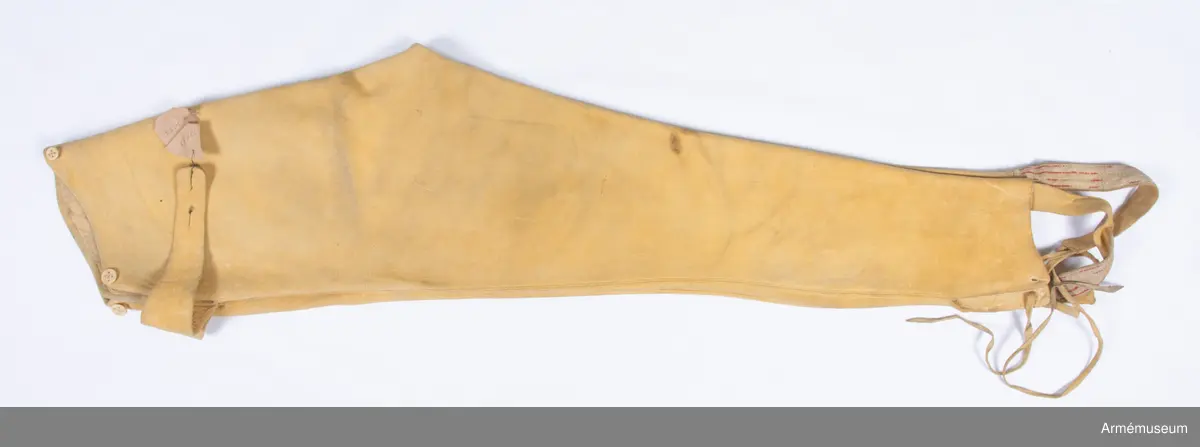 Gula skinnbyxor med knytband under foten.

Byxorna är sydda av gult sämskskinn med falsk smal lucka fram. Skinnet kan vara av älg, och är upp till 5 mm tjockt på vissa ställen.
Två stolpar som ska härma sidöpningarna på en lucka är applicerade ovanpå framstycket, och nedsytt med stickningar. I varje sida av den stora luckan sitter en spänntamp av skinn avsedd att knäppas ihop i ryggen.
Den egentliga öppningen är i sidorna där luckan stängs med stora knappar. Byxorna är konstruerade med två fram- och två bakstycken. De är ofodrade, men har infodringar i linningen och luckan av tunnt skinn i samma färg, samt vid alla punkter där plagget utsätts för extra slitage.
Nertill i varje bens utsida finns en ca 11-12 cm hög slits samt en hälla fastsatt för att fästas under foten. Hällan är av samma skinn som byxorna, och förstärkt med ett vävt röd och vitrandigt band. De vita trådarna i bandet är troligen av lin, medan de röda (som nästan är bortnötta) ser ut att vara av ull. I änden av varje hälla sitter två skinnremmar för snörning i sydda snörhål på motsatt sida vid slitsen.
Knapparna är av ben och i två storlekar. En stor sitter i varje sida av luckan, medan 2 små fram och bak troligen är till för fastsättning av hängslen. Knapp saknas i spänntampen bak. Knapphålen i luckan är passpoalerade.
Byxornas linning är kantad med passpoal av skinn.
Hela plagget är troligen färgat efter sömnad, för man kan se att lintråden som man har sytt alla sömmar med också är gul.
Sömnadsarbetet är mycket skickligt utfört, och samtliga delsömmar pryds med en stickning på varje sida.
