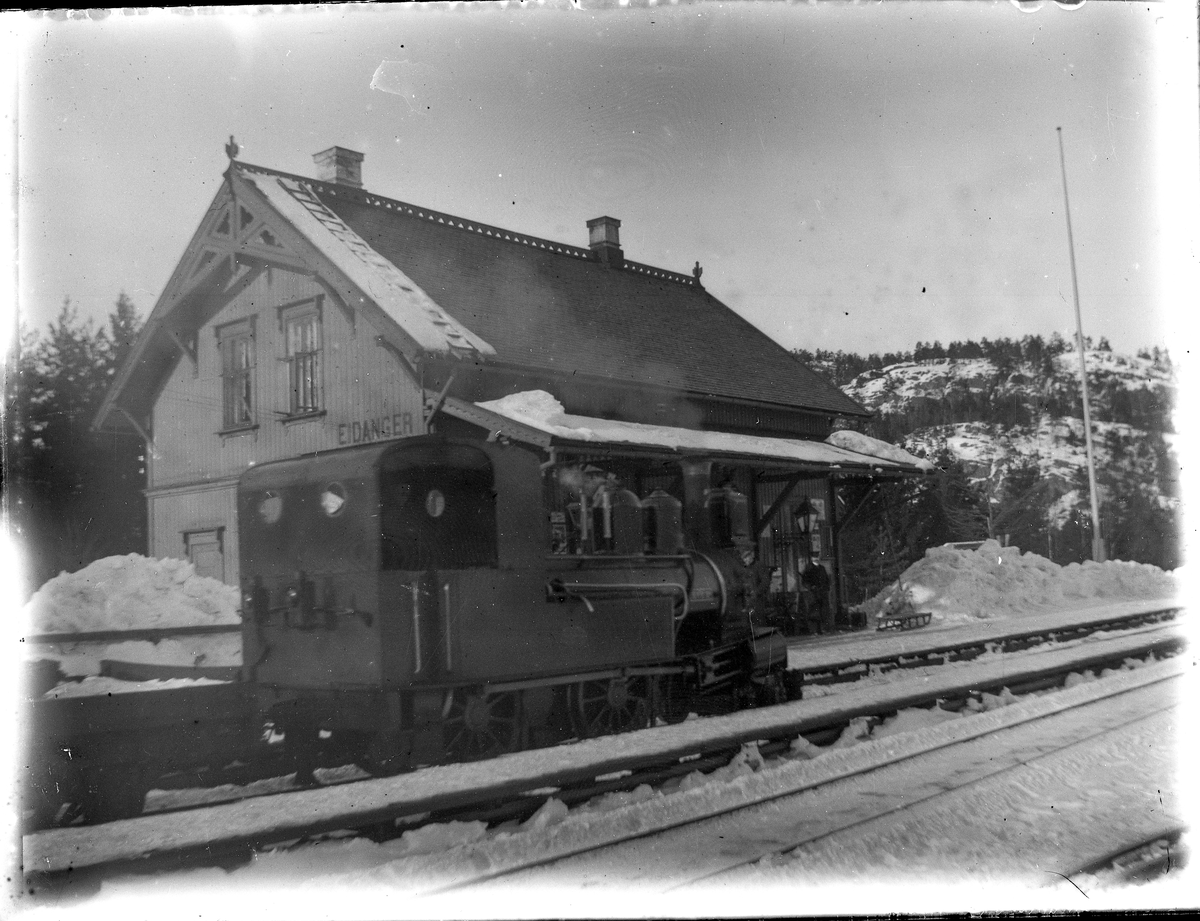 Foto av damplokomotiv type IV nr. 7 SKRIM på Eidanger stasjon 

Fotosamling etter Bendik Ketilson Taraldlien (1863-1951) Fyresdal. Gårdbruker, fotograf og skogbruksmann. Fotosamlingen etter fotograf Taraldlien dokumenterer områdene Fyresdal og omegn. 
Eidanger stasjon, med damplokomotiv.
