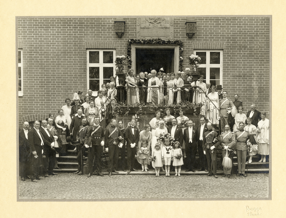 Ett societetsbröllop på Örtofta slott. 
Bröllop 19/5 1921 mellan fröken Stina-Brita Bennet, dotter t. friherren och godsägaren Jacob Erland Bennet och h.h. Anna, f. Rosenblad, och greve Ove Thott. 
Man har samlats vid dubbeltrappan vid huvudingången. På stenreliefen över porten syns ätterna Stenbocks och
Barnekows vapen, året 1728 och följande inskription: "Thetta huset utan fara, Wärdes Herren så bevara
Att thet wäl och länge står, Rätter arving alltid får."