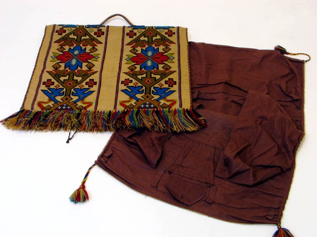 Nattsäck i 2 delar. Tillverkad i broderat säckvävsmaterial. Mönstret består av symmetriska stjärnor och sicksackmönster i blått, grönt, röttoch brunt. Handtag i läder. Fransar i kanterna. En del är fodrad med brunt foder med olika fickor och fack.
Nattsäck, förr benämning på en väska, ofta säckliknande och av grovt tyg eller läder, vari en resande förvarade nattsaker och kläder.