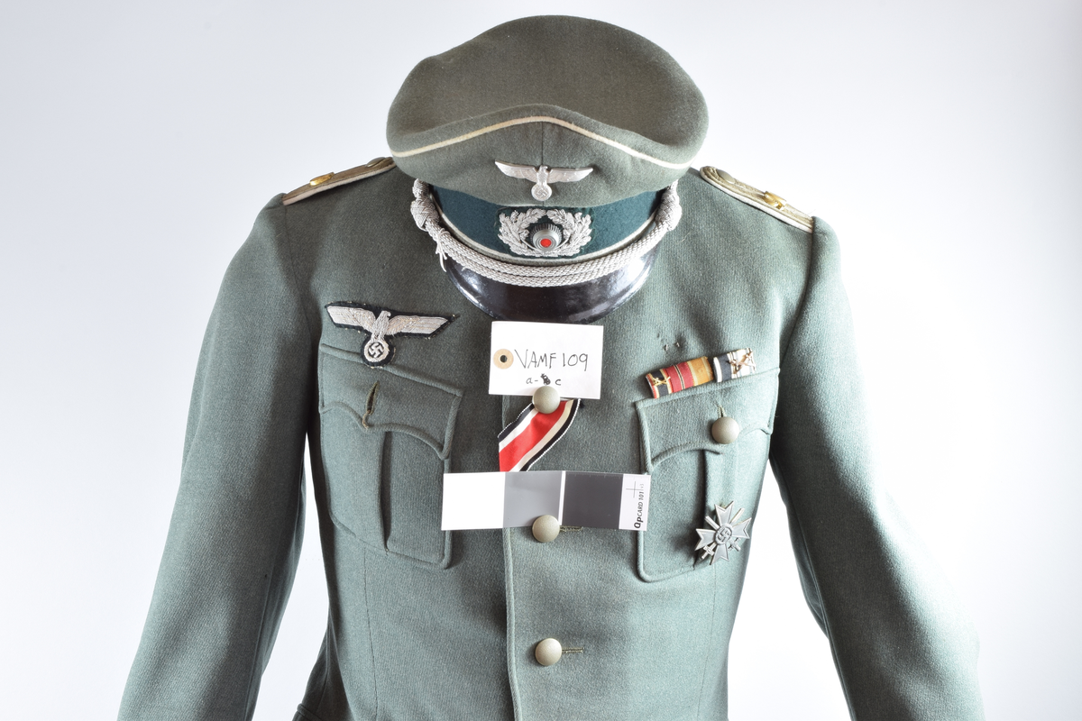 Offiseruniform for den tyske hær, infanteri. Består av uniformsjakke i grønn fin ull og innvendig silkefor med tilhørende hatt (buksen er ikke original). Den tyske riksørnen med hakekors er sydd på høyre bryst.