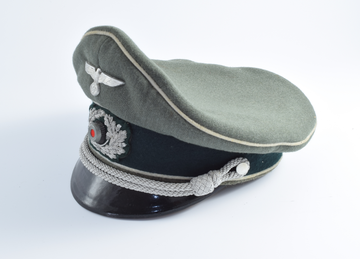 Offiseruniform for den tyske hær, infanteri. Består av uniformsjakke i grønn fin ull og innvendig silkefor med tilhørende hatt (buksen er ikke original). Den tyske riksørnen med hakekors er sydd på høyre bryst.