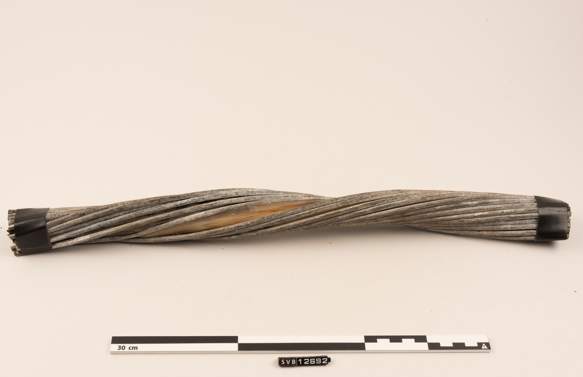 En halv meter lang bit av en skadet fiberkabel. Kabelen består av flere lag , og er 3,5 centimeter tykk i ytre diameter (inkludert integrert strømforsyning).  Kabelens oppbygging er:
•	Innerst ligger optiske fibre som leder lyssignalene
•	Fibrene ligger i en gel i et rør av plast
•	Utenpå dette ligger armeringstråder av stål
•	Disse er omgitt av kobberbånd som leder strøm
•	Neste lag er beskyttelse av polyethylen
•	Utenpå dette er det spunnet kraftig stålarmering
•	Ytterst er et lag av tjæreinnsatt jute 

Denne 1/2 meter lange biten av den ca. 200 m lange skadde delen, har mistet det ytterste laget og er vridd. Kabelen var aldri totalt brutt. Den innerste delen var hel. Ansatte i Space Norway skar av denne kabelbiten. De festet tape rundt begge ender slik at stålarmeringen ikke skulle gå fra hverandre. Museets konsevator erstattet denne tapen med en som var mer solid.