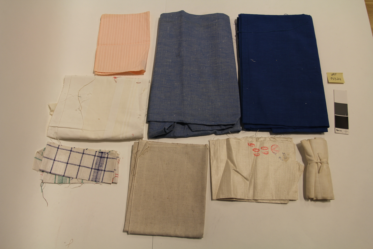 Stoffrester og/eller vareprøver i ulik kvalitet. Flere med klippekant og flisete ender.
Hvitt håndkle/frottestoff med brodert inn "FRED OLSEN LINES", hvitt stivt bomullstoff i tre biter i ulik størrelse, hvitt linstoff, hvitt håndkle med blå striper med vevd inn "VALKYRIE" og påsydd merkelapp fra Joh. Petersen, hvitt bomullstoff med påsydd blondekant i hullsøm, hvitt kreppstoff, hvitt stoff pakket inn med bånd, vareprøver på håndklestoff med striper i rødt, blått og grønt, to av dem med klisterlapper merket B. 550, hvitt stoff i fiskebeinsvev med rødt stempel og påskrevet med kulepenn, lys rosa kreppstoff, hvit stripete stoff i bomull med striper i eggehvit, grovvevd stoff i nærmere grå, stort stoffstykke i grovvevd klar blå lin, et likt i lyseblå.