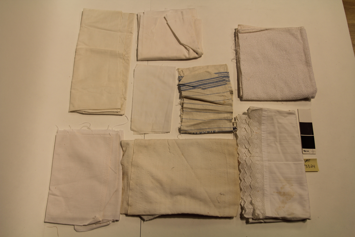 Stoffrester og/eller vareprøver i ulik kvalitet. Flere med klippekant og flisete ender.
Hvitt håndkle/frottestoff med brodert inn "FRED OLSEN LINES", hvitt stivt bomullstoff i tre biter i ulik størrelse, hvitt linstoff, hvitt håndkle med blå striper med vevd inn "VALKYRIE" og påsydd merkelapp fra Joh. Petersen, hvitt bomullstoff med påsydd blondekant i hullsøm, hvitt kreppstoff, hvitt stoff pakket inn med bånd, vareprøver på håndklestoff med striper i rødt, blått og grønt, to av dem med klisterlapper merket B. 550, hvitt stoff i fiskebeinsvev med rødt stempel og påskrevet med kulepenn, lys rosa kreppstoff, hvit stripete stoff i bomull med striper i eggehvit, grovvevd stoff i nærmere grå, stort stoffstykke i grovvevd klar blå lin, et likt i lyseblå.