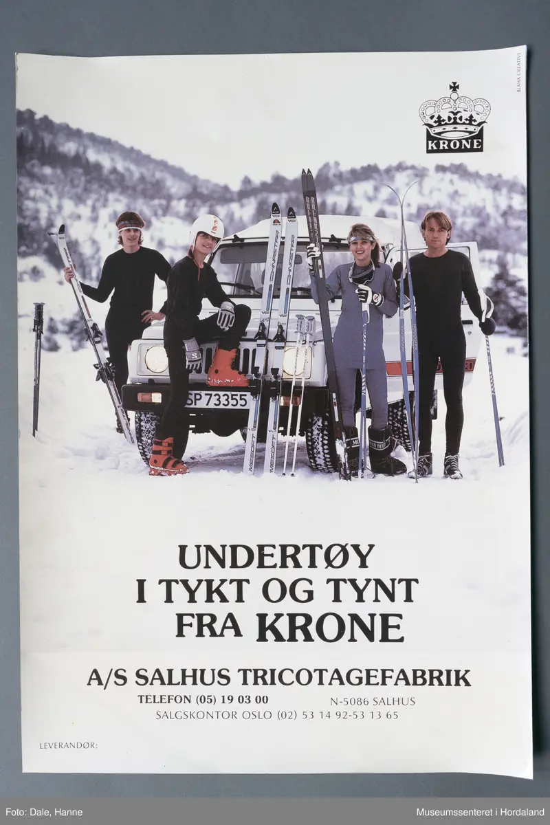 Fire menneske med ski ved bil i vinterlandskap, alle kledd i ulltøy.