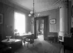 Araby herrgård. ca. 1910.
Interiör av ett arbetsrum. Man ser ut i ett vardagsrum/bibliotek.