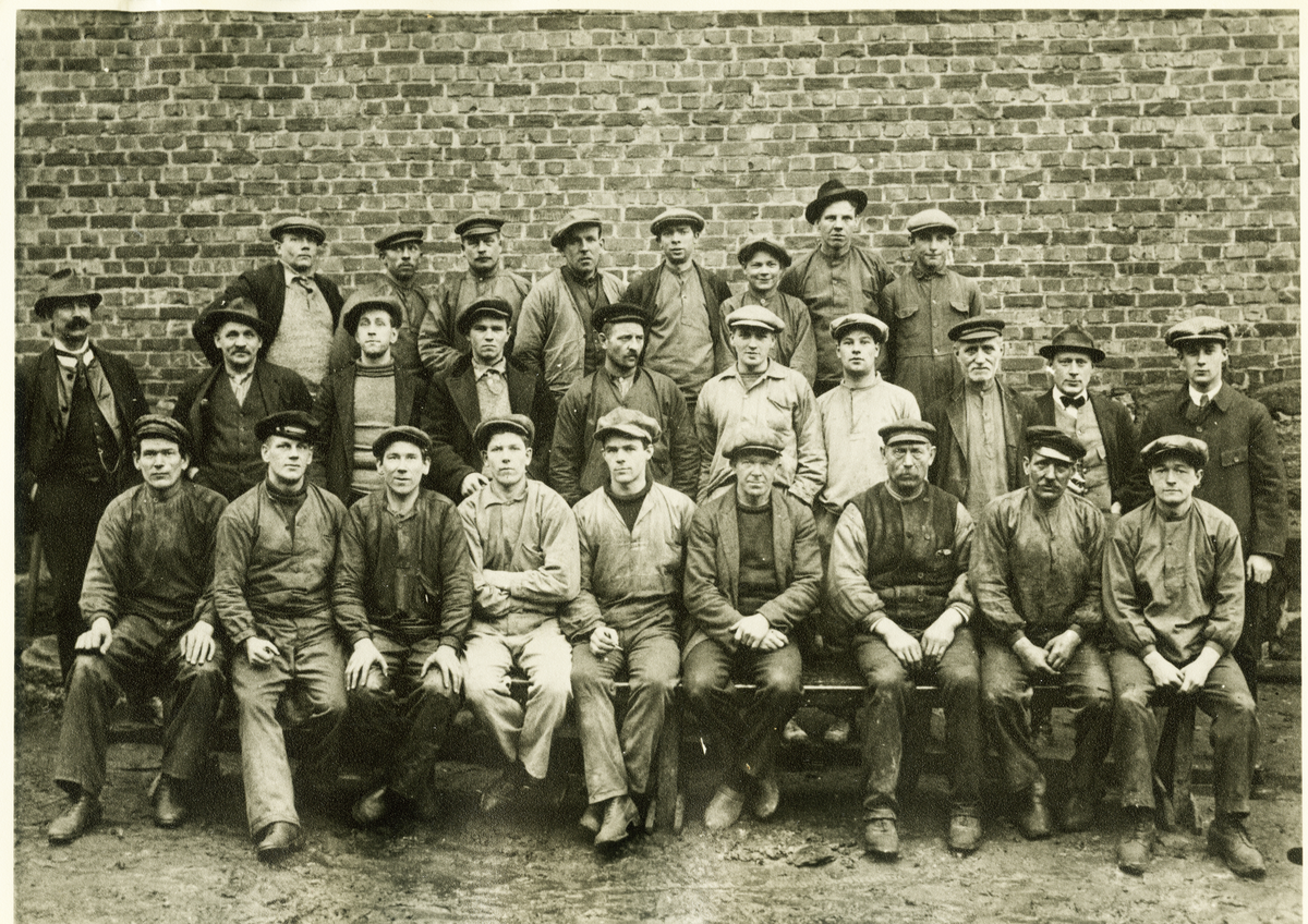 Gruppbild. Delar av arbetsstyrkan år 1924. Fr. v. övr. raden 1.*Hilding Albanus Stockelberg (29/5 1889 Fässberg-), 2. Hilmer Berndtsson, 3. Nils Persson, 4. Fritiof Andersson, 5. Sven Frisk, 6. Karl Strömberg, 7. Ernst Berg och 8. Thure Björkman. Mittraden fr. v. 9. Eric Gustaf Hedenberg(född 1875 som Henriksson), 10. Carl Nilsson, 11. Johan Ahl, 12. Samuel Andersson,13. *Oska Alexius Eliasson (f.1890), 14. Erik Nilsson,15.  Arvid Qvist, 16. Alfred Thorsson, 17. *Fritz Otto Gustaf Meyer (21/11 1897 Tyska S:t Getud Stockholm-, Civilingenjör) och 18. Olof "Olle" Hedenberg. Sittande fr. v. 19. *Vidar Barthold Jansson (27/12 1891 Fässberg-), Nr 19 var bror till nr. 21 och 22. 20. Theodor Berndtsson, 21. *Vilhelm Fredrik Jansson( 30/3 1897), 22. *Arthur Reinhold Jansson (16/8 1901), 23. Torsten *Herbert Eliasson (13/3 1903), 24. *Karl Gustaf Blom (1/8 1887, Tvååker), 25. Axel Johansson, 26. Martin Engberg (31/5 1875, Skrea) och 27. John Larsson