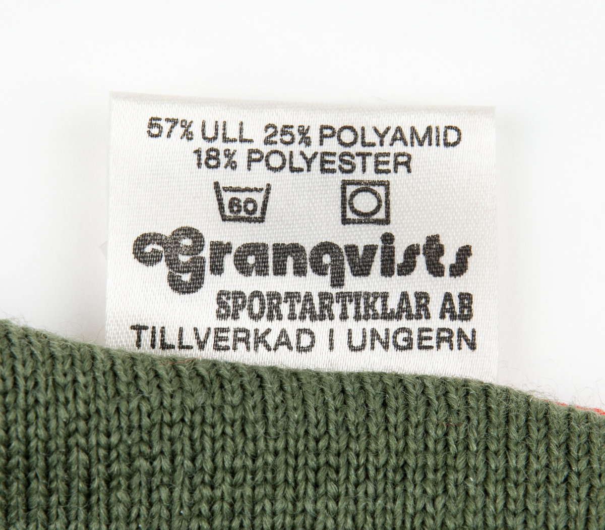 Ett par tumhandskar, fältuniformsystemet 90. Ytterhandsken är förstärkt med vitt gerskin. På handsken sitter remmar samt kardborreband för åtspänning samt remmar med metalring för fastsättning i plagg. I handsken urtagbara fodervantar.