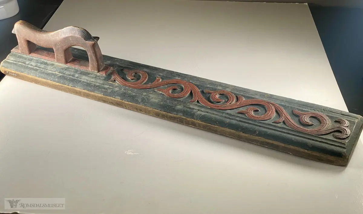 Håndtaket er utskåret som en hest med mulen ned mot treet. utskårede akantusranker i flatskurd som slynger i treets lengde.