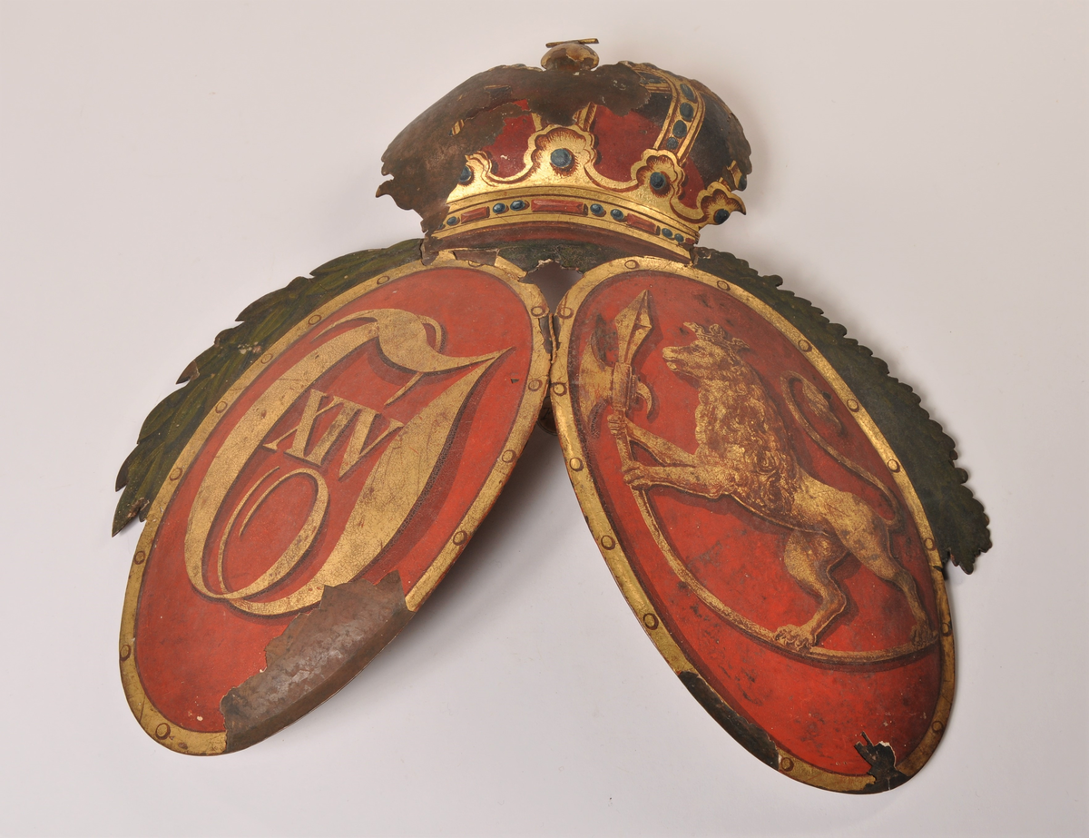 Våpenskjold med norsk løve og Karl XIV Johanns monogram med kongekrone over. Gullmonogram på rød bargrunn. Grønne løv - laur (?) over mongrammet, eik over løven.